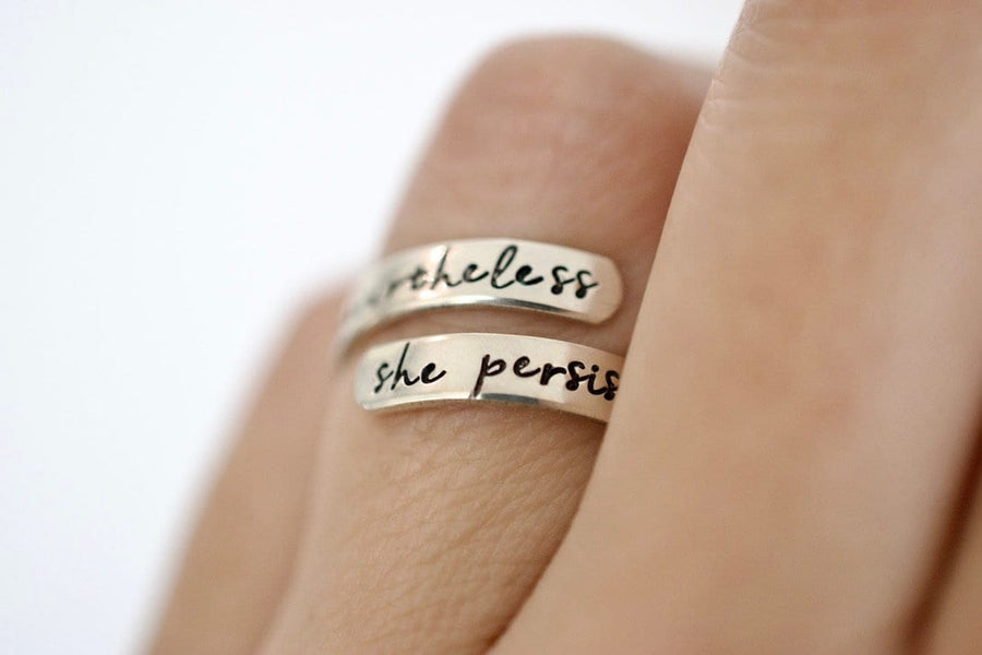 Sterling silver wrap ring with the text &quot;nevertheless&quot; on the top and &quot;she persisted&quot; on the bottom